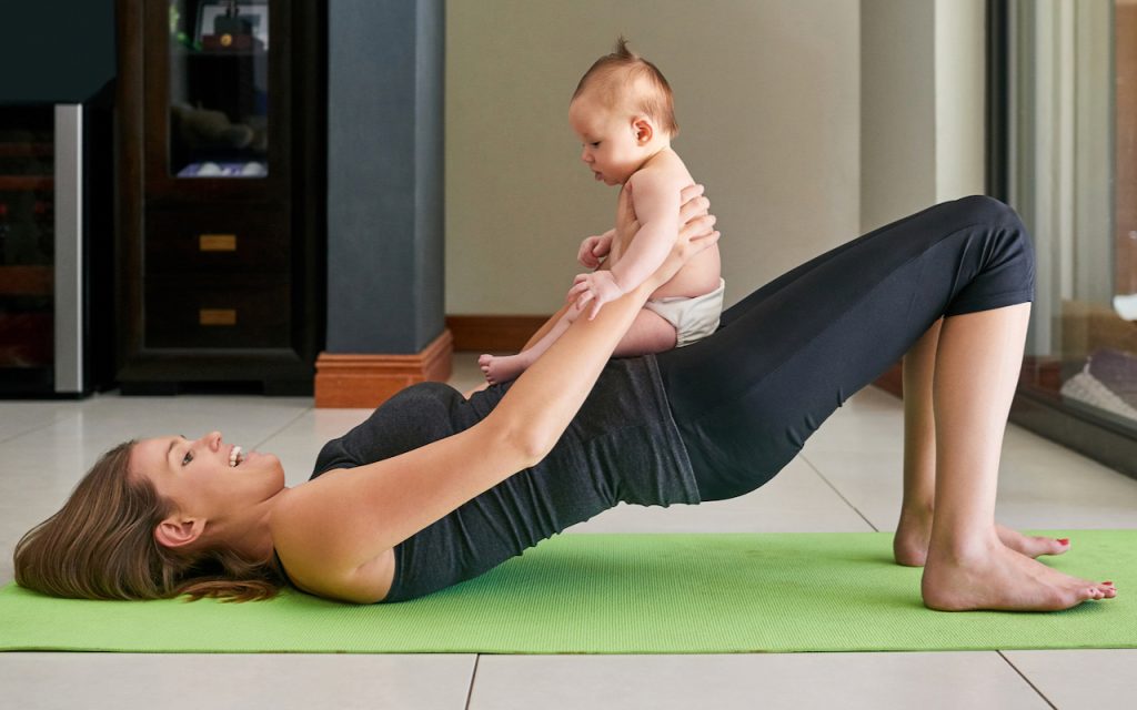 A new mother practices yoga with her baby.