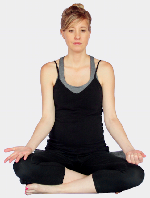 A photo of a pregnant person demonstrating an alternate version of nadi shodhana at MamaSpace Yoga