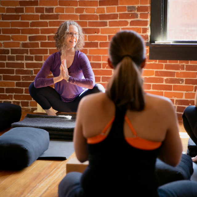 Carol Gray teaching malasana - frog squat in a prenatal yoga class at MamaSpace Yoga