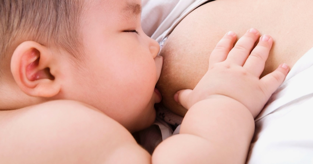 A photo of a breastfeeding baby illustrating a post about CST and breastfeeding