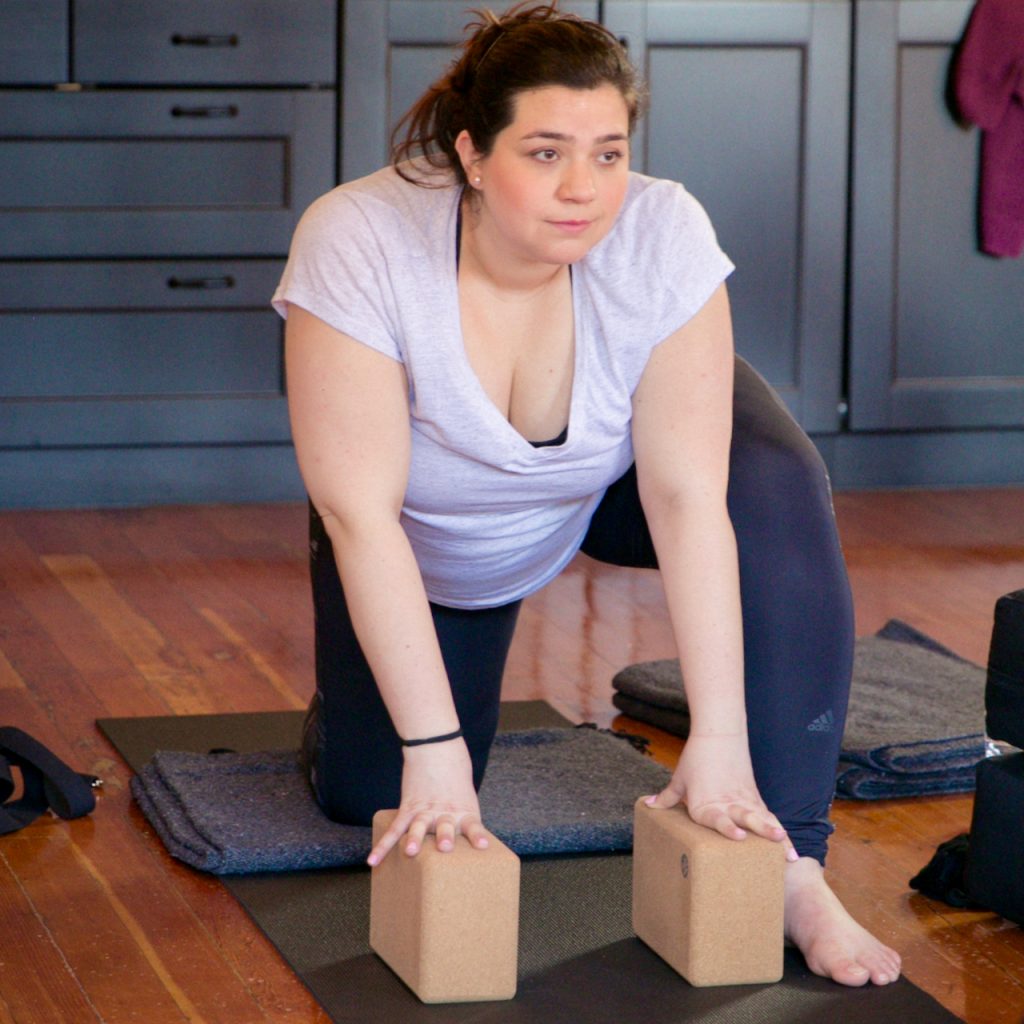 A photo of a pregnant person using blocks and a blanket in a prenatal yoga class at MamaSpace Yoga
