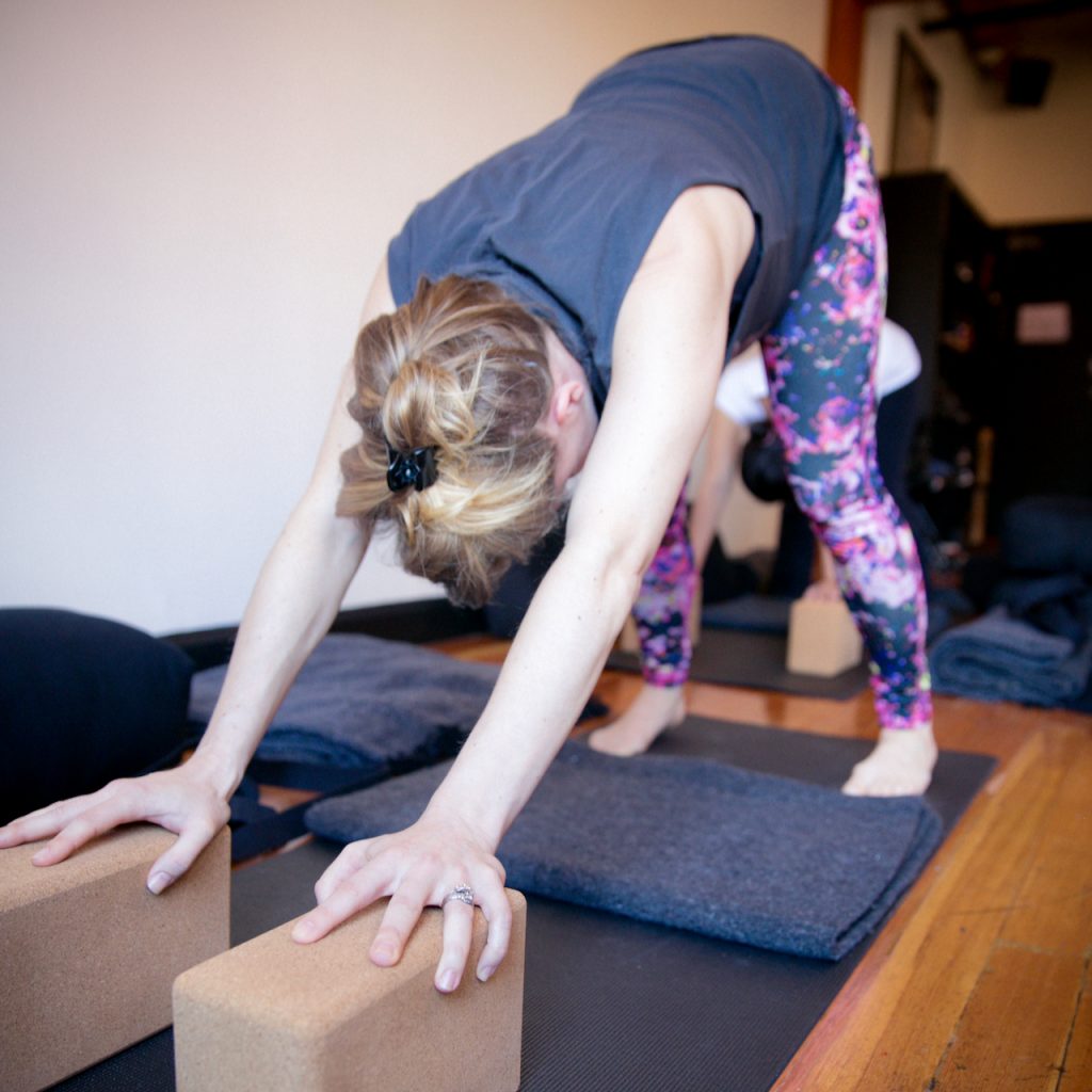 A pregnant woman practicing Downward Facing Dog at MamaSpace Yoga