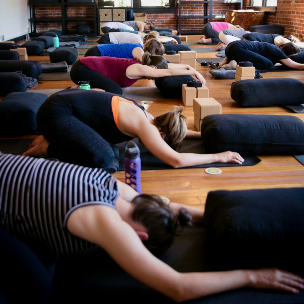 Pregnant people practicing Child's Pose at MamaSpace Yoga