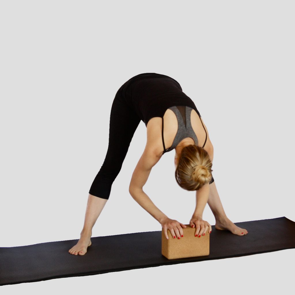 A photo of a pregnant person using blocks in a prenatal yoga class at MamaSpace Yoga