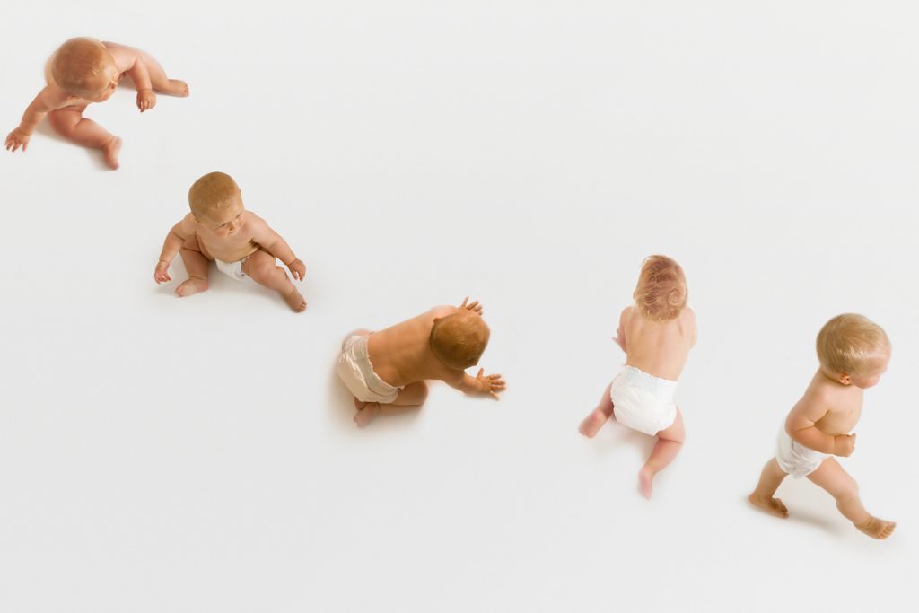 Photo of a Baby Moving From Seated to Hands and Knees to Walking