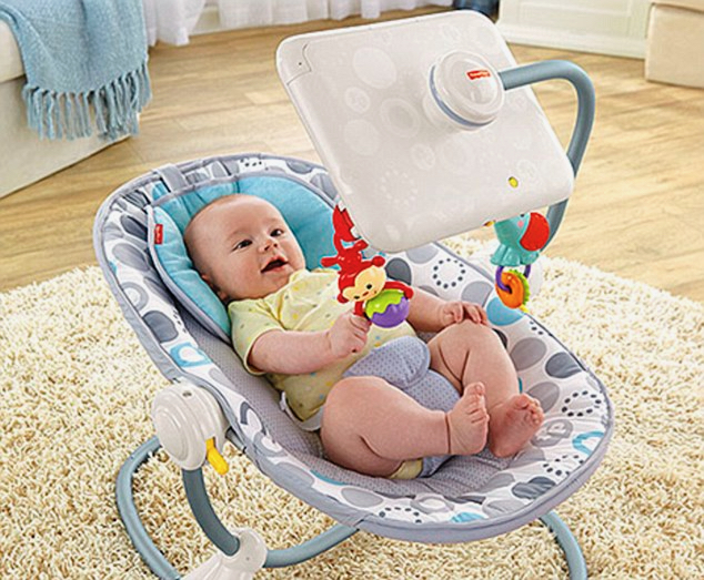 A photo of a baby in an infant seat that has a bracket to hold a tablet