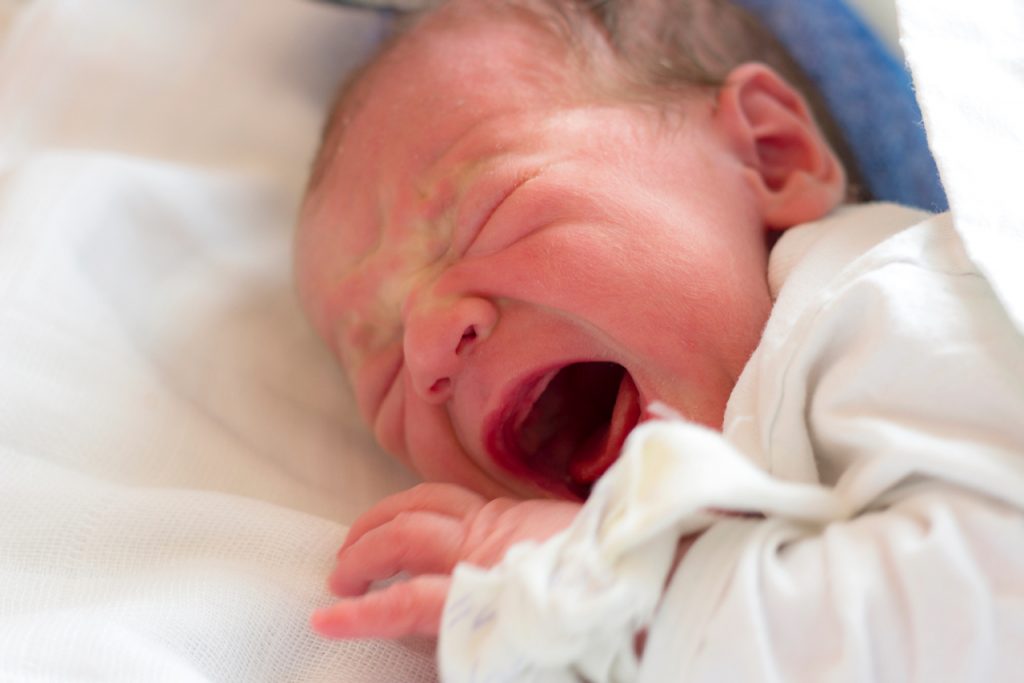 A photo of a crying newborn